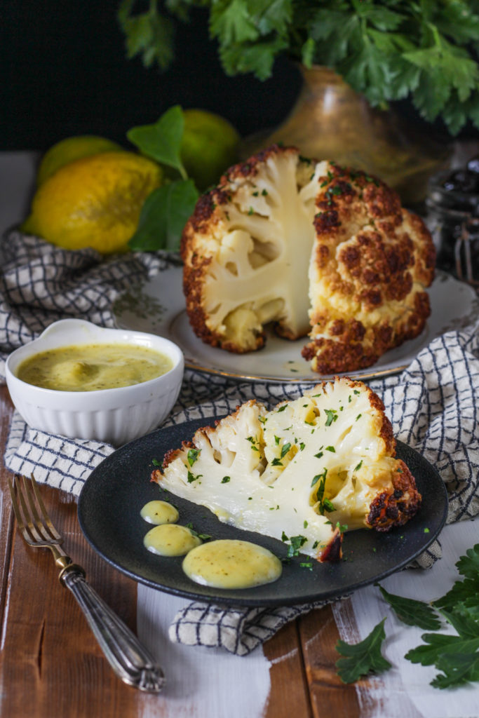 Fiore di cavolfiore al forno con salsa al limone ricetta vegan fetta pronta da gustare